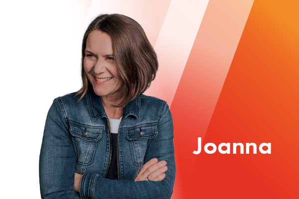 Portrait einer lachenden Frau mit dunklen Haaren, die eine Jeansjacke trägt.