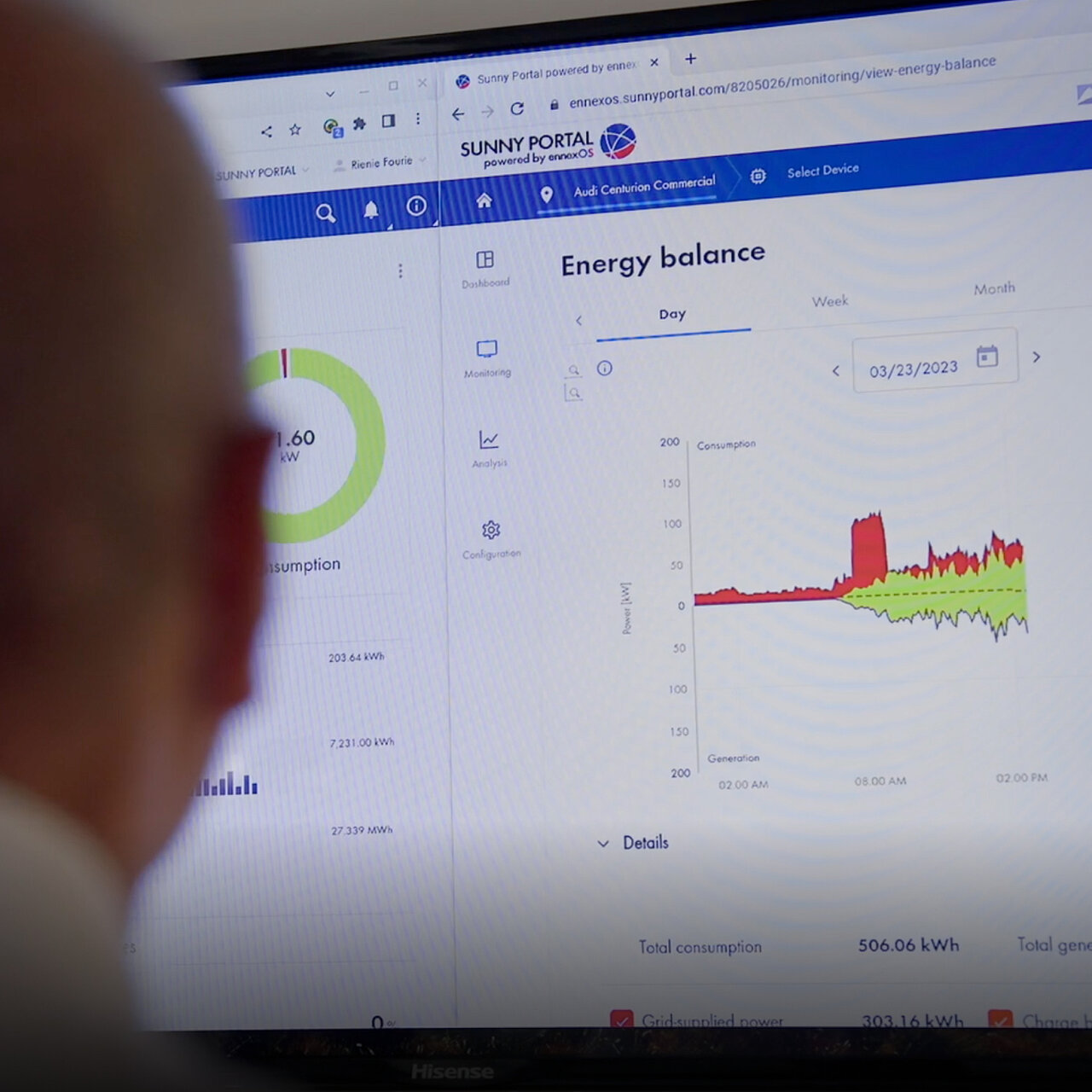 A person is sitting in front of a computer screen displaying the Sunny Portal and the energy balance of a solar power system, showing both consumption and generation.