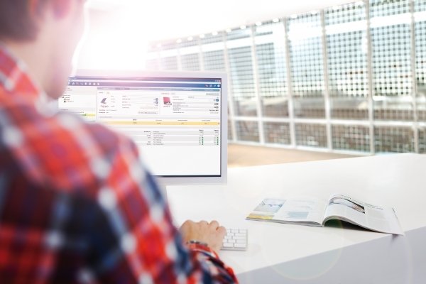 Eine Person sitz an einem Computer.